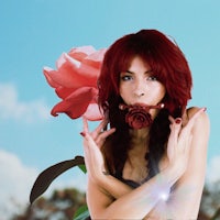 a woman with red hair holding a rose